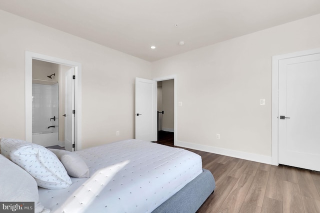 bedroom with recessed lighting, wood finished floors, and baseboards