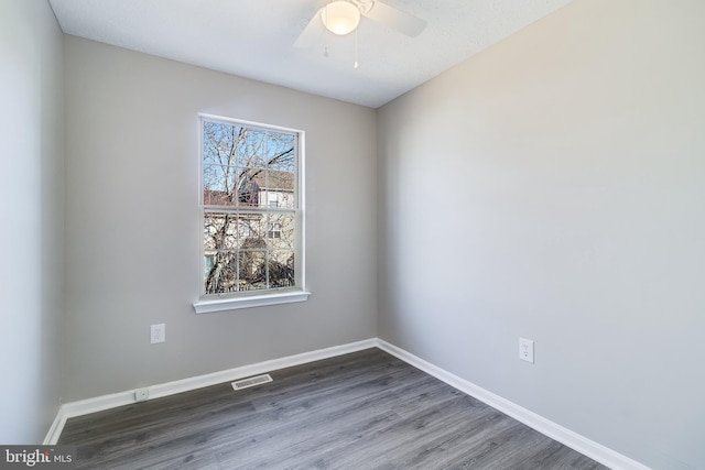 unfurnished room featuring visible vents, ceiling fan, baseboards, and wood finished floors