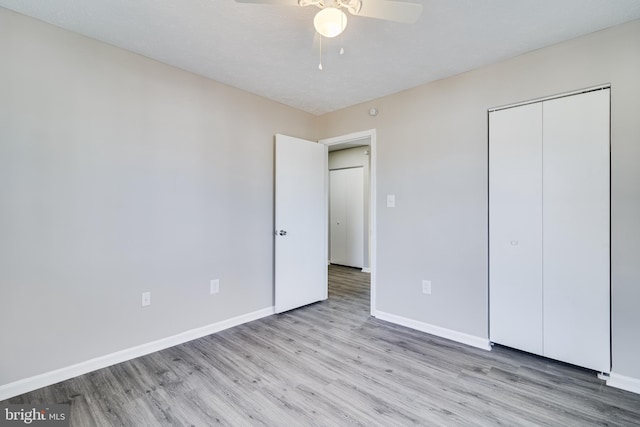 unfurnished bedroom with ceiling fan, a closet, baseboards, and wood finished floors