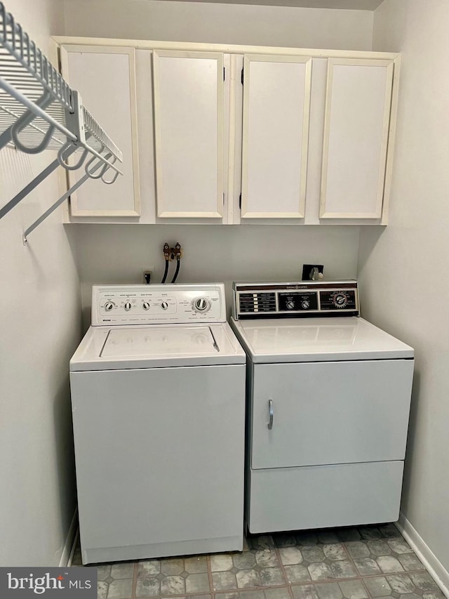 washroom featuring cabinet space, independent washer and dryer, and baseboards