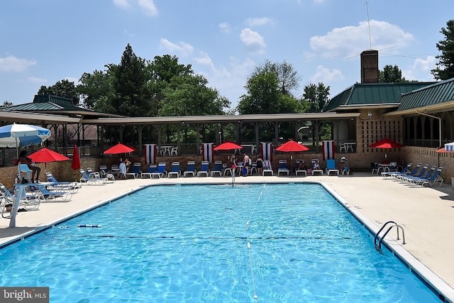 pool with a patio and fence