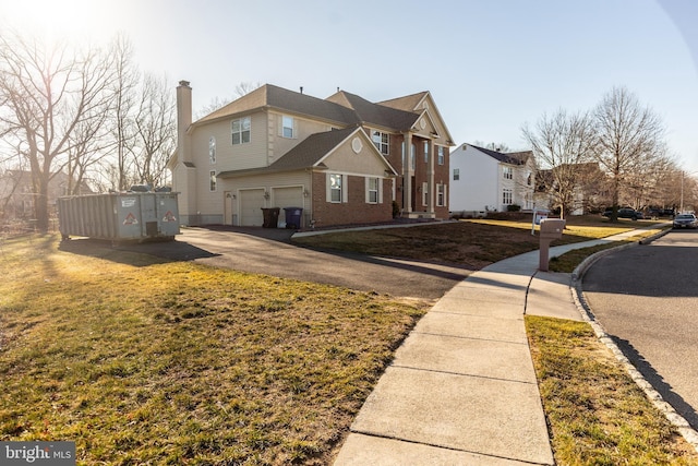 view of side of property with a garage, a lawn, brick siding, and a chimney