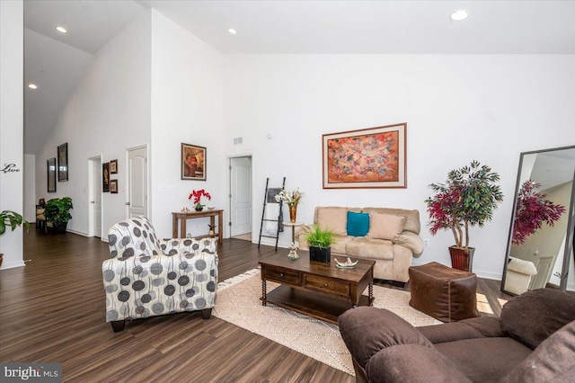 living area with dark wood-type flooring, recessed lighting, visible vents, and high vaulted ceiling