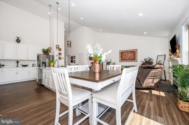 dining area featuring high vaulted ceiling, dark wood-type flooring, and recessed lighting