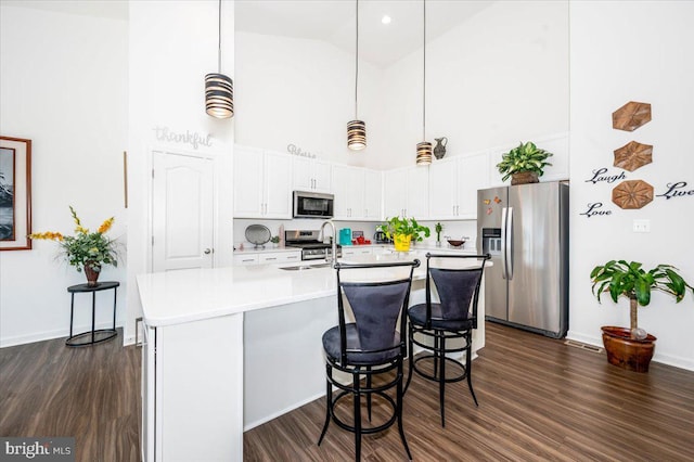 kitchen featuring white cabinets, dark wood finished floors, stainless steel appliances, and a sink