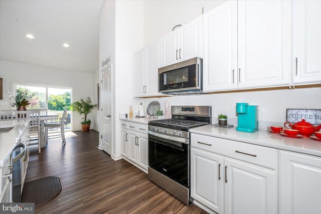 kitchen featuring appliances with stainless steel finishes, light countertops, white cabinets, and dark wood-type flooring