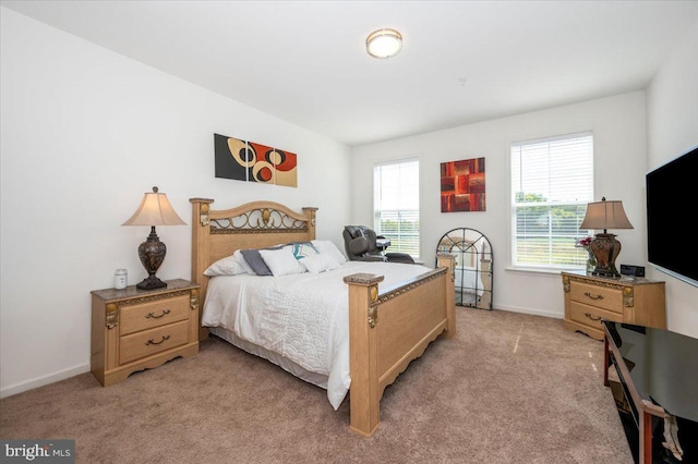 bedroom featuring light carpet and baseboards