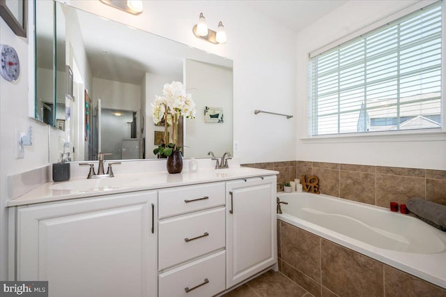 full bathroom featuring double vanity, a garden tub, a sink, and tile patterned floors