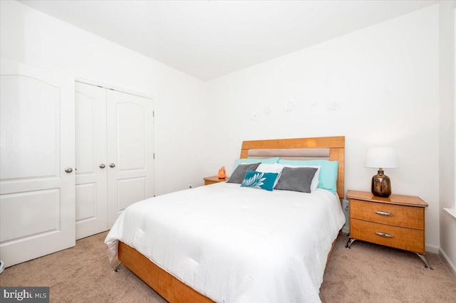 bedroom with a closet and light carpet