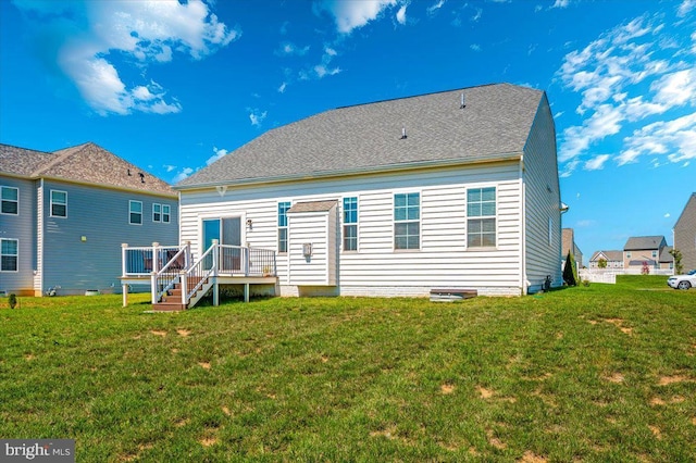 rear view of house featuring a deck and a yard