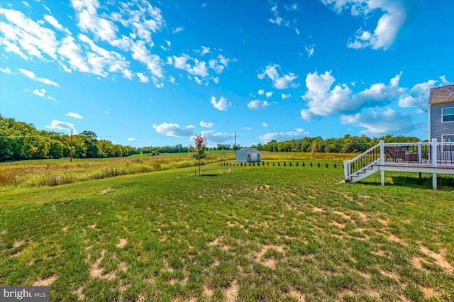 view of yard with a deck and a rural view