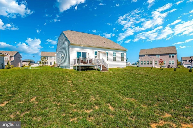 rear view of property featuring crawl space, a deck, and a lawn