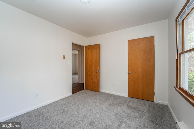 unfurnished bedroom with carpet flooring and baseboards