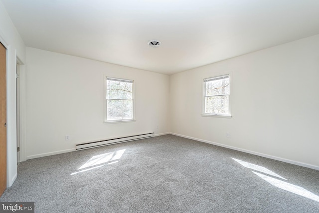 carpeted spare room featuring a healthy amount of sunlight, visible vents, baseboards, and baseboard heating