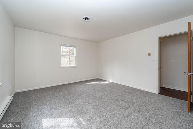 carpeted spare room featuring baseboards, visible vents, and baseboard heating