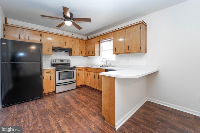 kitchen with under cabinet range hood, a peninsula, dark wood-style flooring, freestanding refrigerator, and stainless steel electric stove