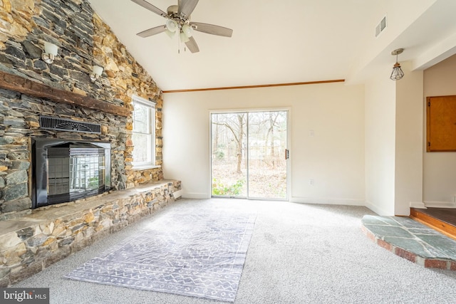 unfurnished living room with visible vents, carpet flooring, a stone fireplace, high vaulted ceiling, and baseboards