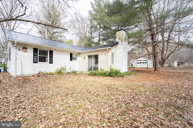 ranch-style house with an outbuilding, metal roof, a chimney, and cooling unit