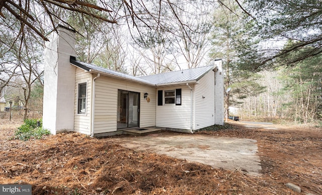 view of front of property with metal roof and a chimney