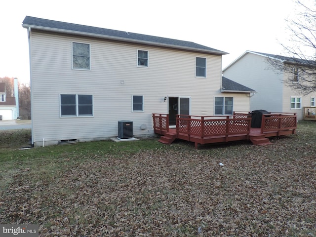 rear view of property featuring central AC unit, a deck, and a yard