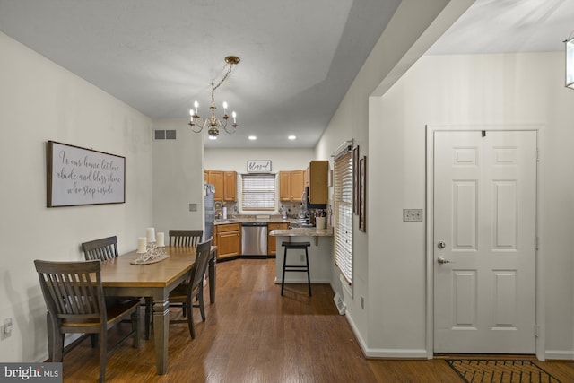 dining room with a chandelier, dark wood-style flooring, visible vents, and baseboards