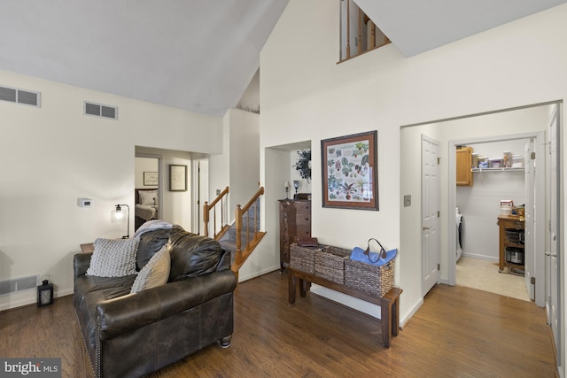 living room with baseboards, stairs, visible vents, and wood finished floors