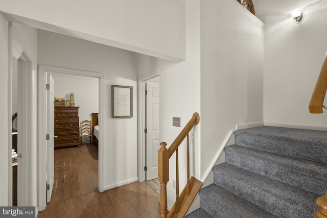 stairway with wood finished floors and baseboards