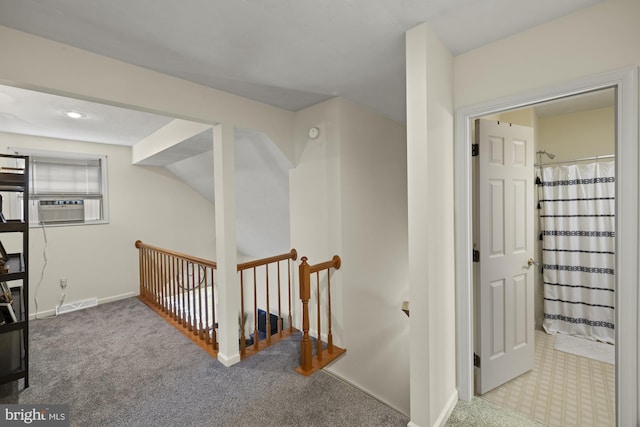 hall with carpet floors, cooling unit, visible vents, and baseboards