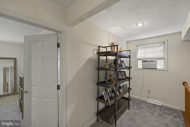 hall featuring visible vents, carpet flooring, a textured ceiling, cooling unit, and baseboards