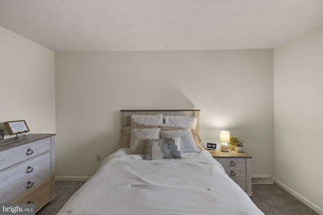 bedroom with baseboards and dark colored carpet