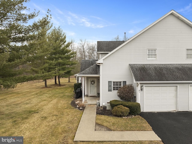 view of front facade featuring roof with shingles, driveway, and a front lawn