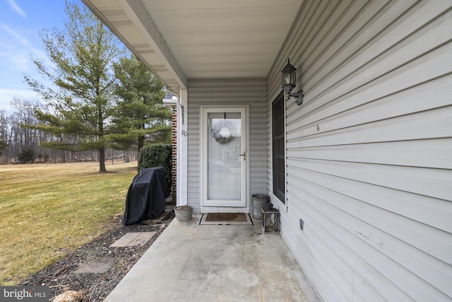 view of exterior entry with a lawn