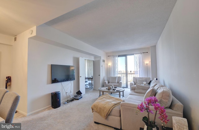 carpeted living area featuring visible vents and baseboards