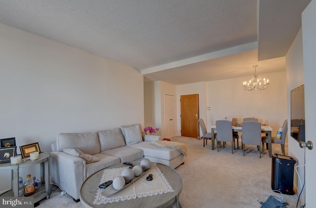 carpeted living room featuring a notable chandelier and a textured ceiling