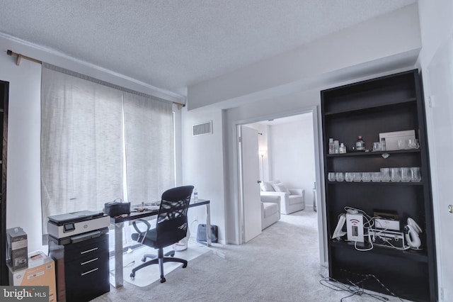 carpeted office featuring visible vents and a textured ceiling