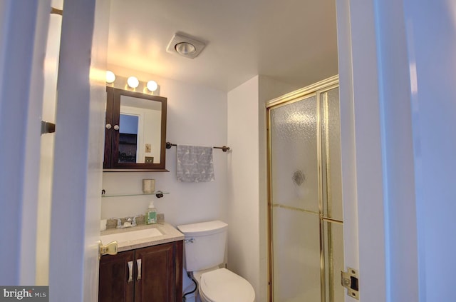 bathroom with a shower stall, toilet, and vanity