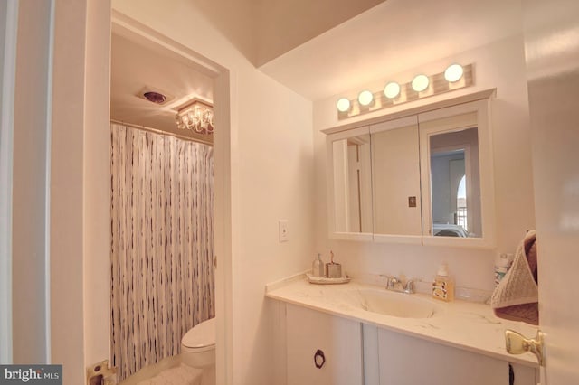 full bathroom featuring a shower with shower curtain, toilet, and vanity