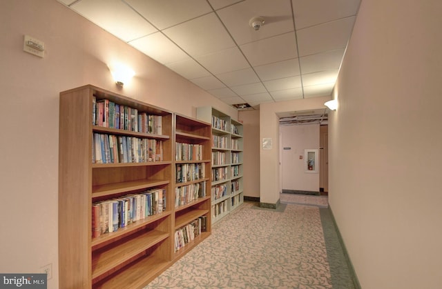 interior space featuring a drop ceiling and baseboards