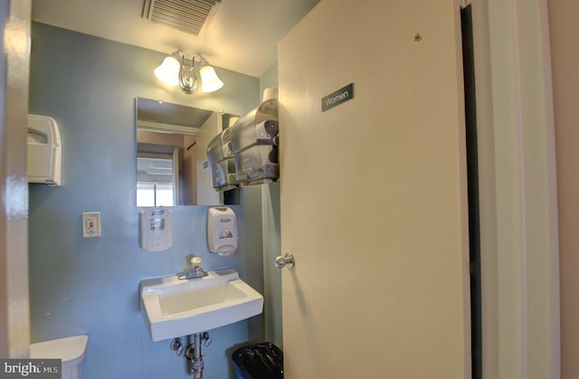 bathroom featuring toilet, visible vents, and a sink