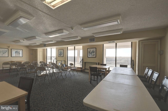 carpeted dining room with visible vents and a textured ceiling