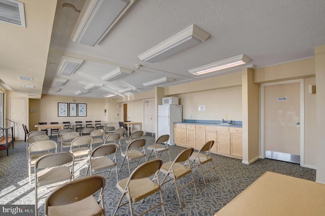 dining area with visible vents, baseboards, a textured ceiling, and dark carpet