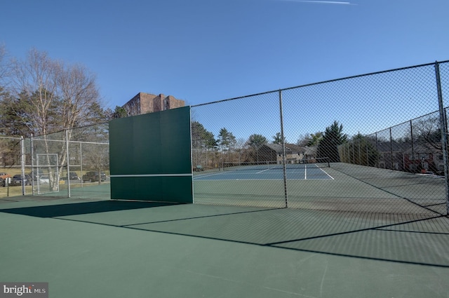 view of tennis court featuring fence