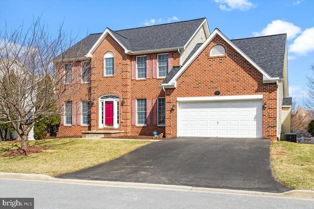 colonial house with brick siding, driveway, an attached garage, and roof with shingles