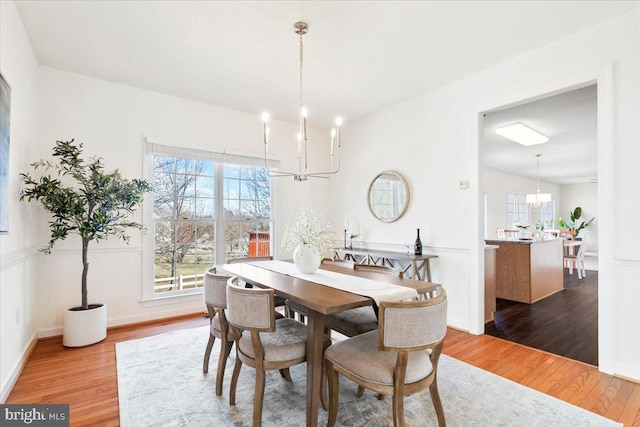 dining area featuring wood finished floors and a chandelier