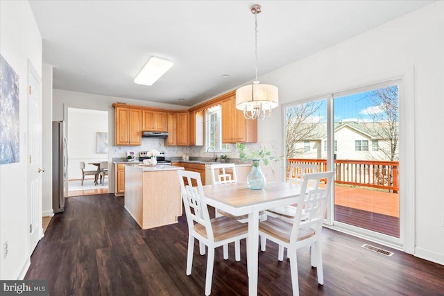 dining area featuring dark wood-style floors, visible vents, baseboards, and a notable chandelier