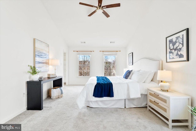 bedroom with vaulted ceiling, light colored carpet, and visible vents