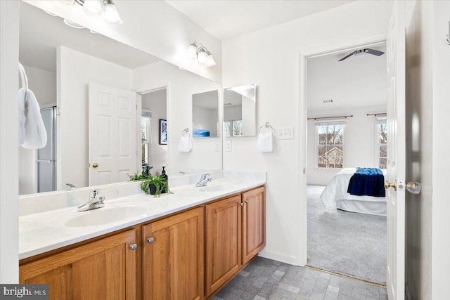 bathroom featuring a sink, baseboards, double vanity, and ensuite bathroom