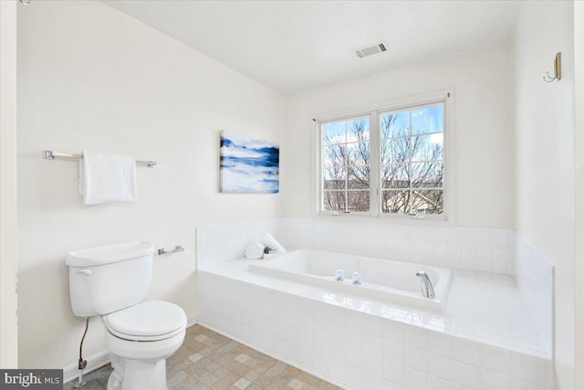 full bathroom featuring a garden tub, toilet, baseboards, and visible vents