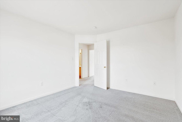 spare room with baseboards and carpet floors