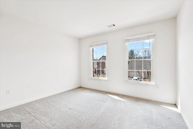 spare room with visible vents, carpet floors, and baseboards